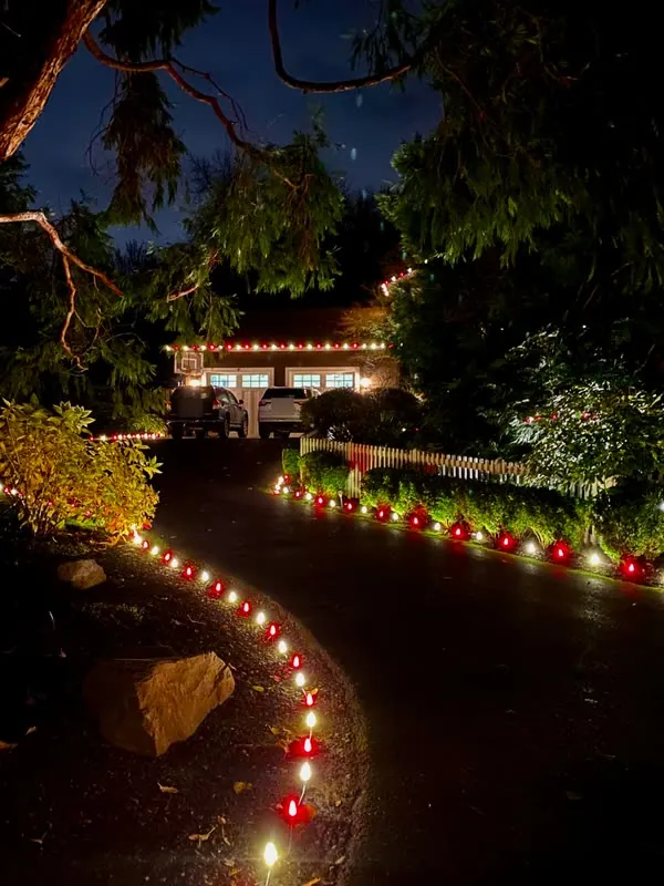 Curving driveway lined with alternating red and white C9 stake lights