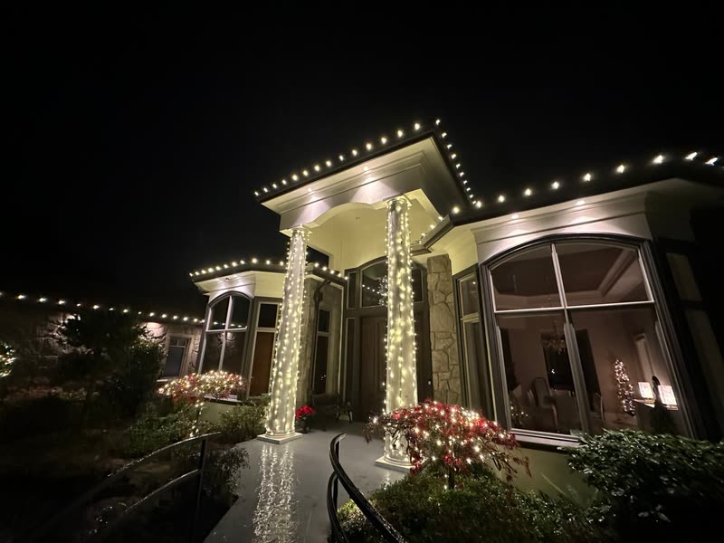 Covered entry with warm white roofline lights and two light-wrapped columns