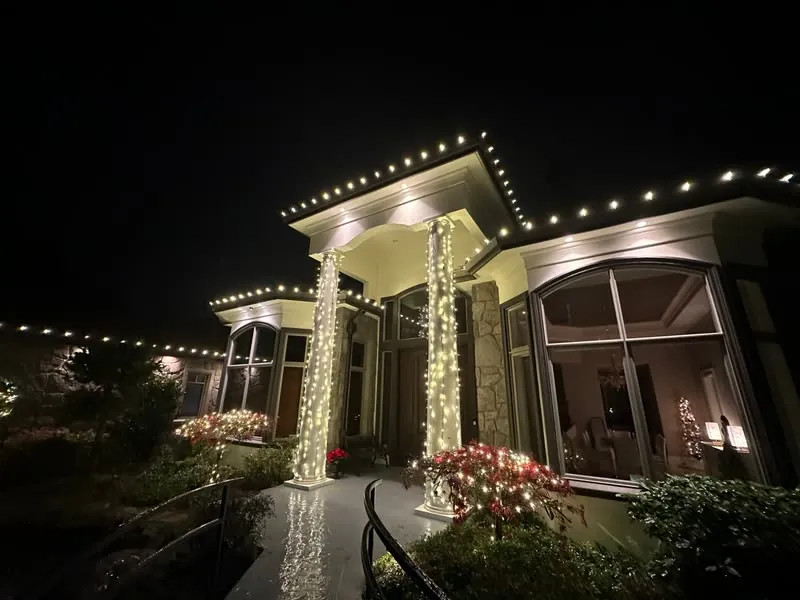 Covered entry with warm white roofline lights and two light-wrapped columns